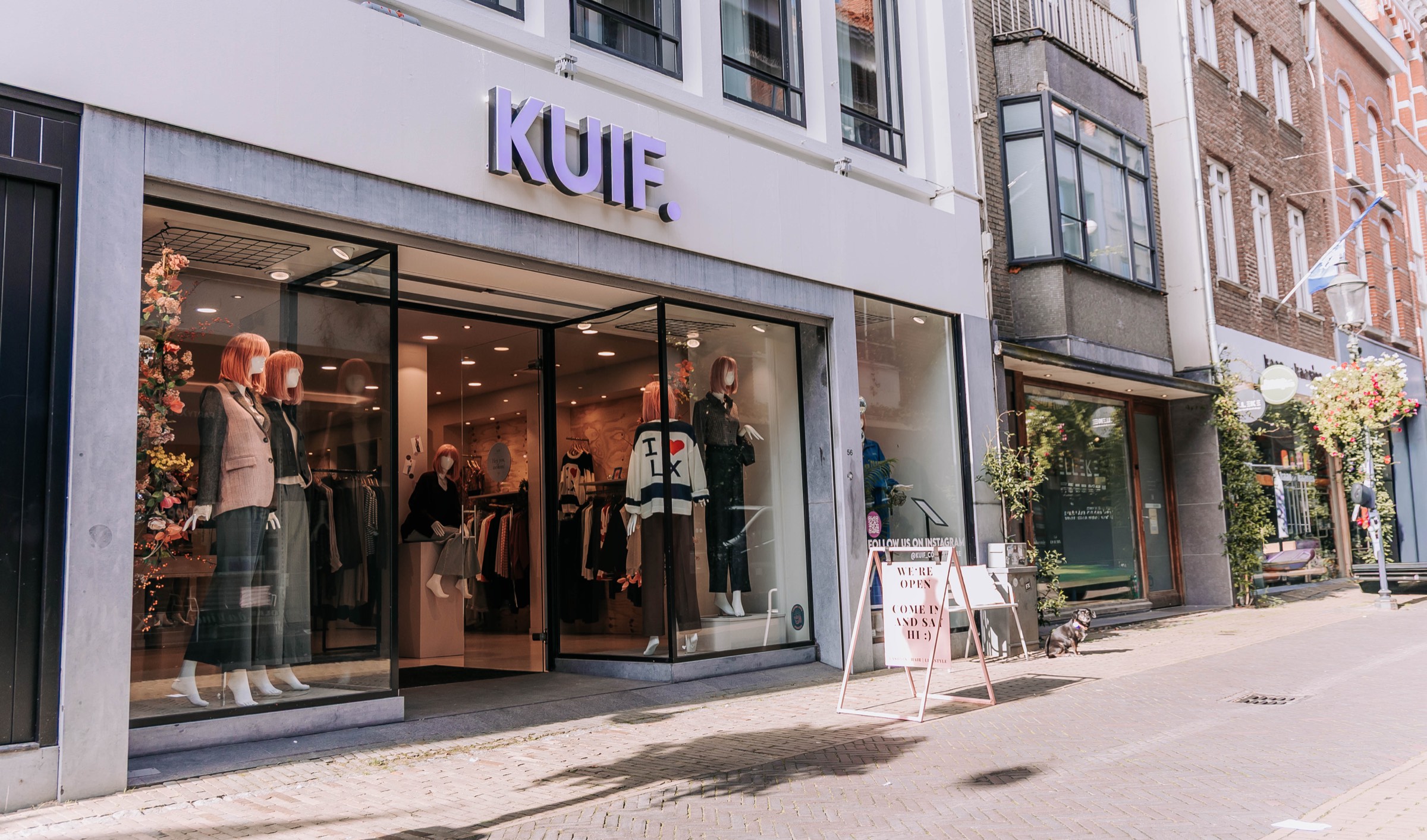 De gevel van KUIF aan de Klaasstraat in Venlo: het paarse woordmerk boven de open deur, etalages met paspoppen en een hondje op de stoep